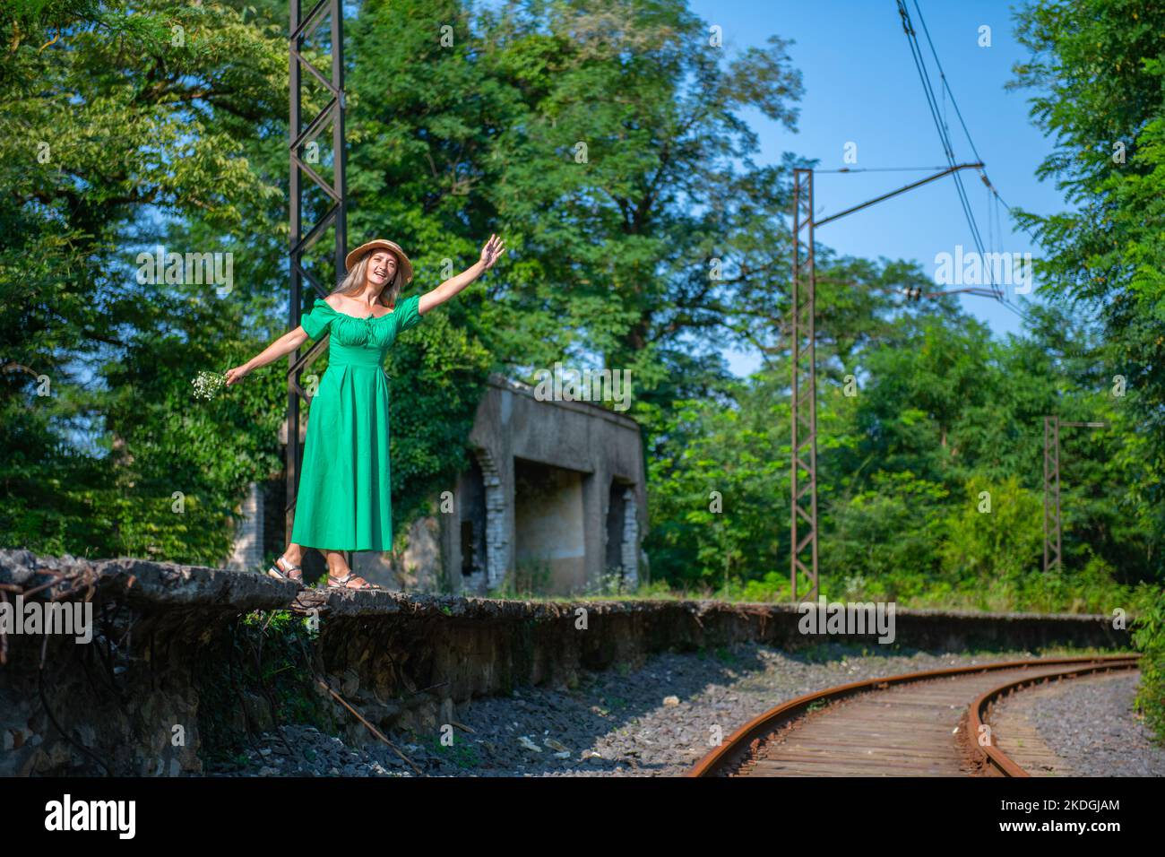 Eine Frau in einem grünen Kleid winkt mit der Hand auf die Eisenbahn Stockfoto