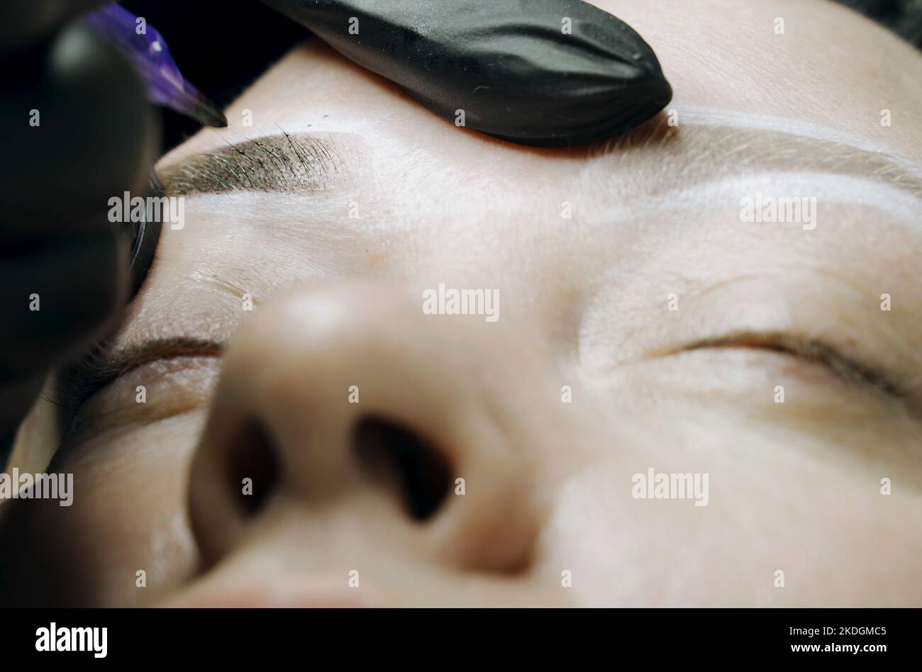 Eine spezielle Nadel Tattoo Maschine macht eine permanente Make-up Korrektur der Augenbrauen einer Frau. Microblading, Pulverbeschichtung Nahaufnahme. Stockfoto