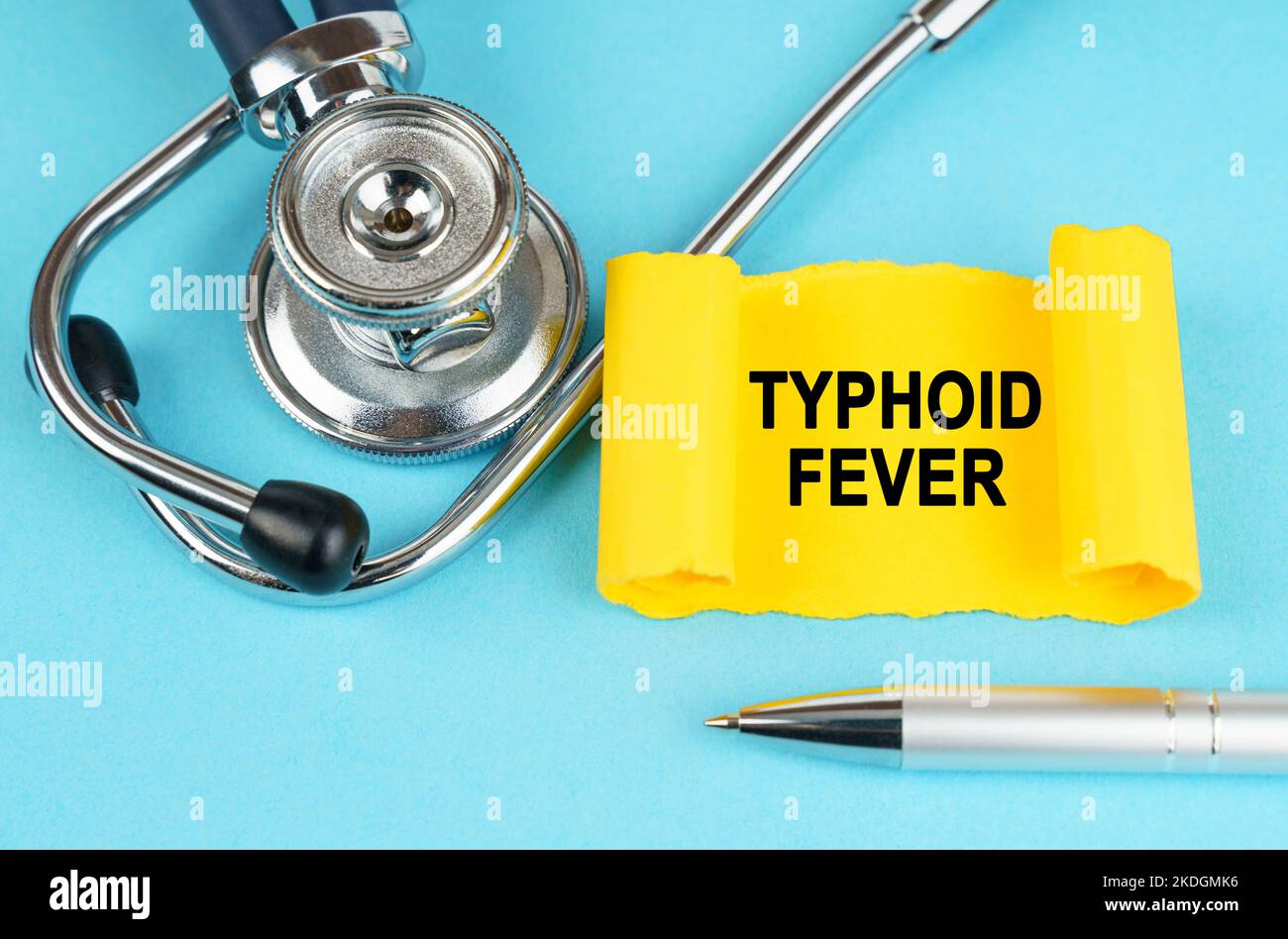 Medizinisches Konzept. Auf der blauen Oberfläche befinden sich ein Stethoskop, ein Stift und ein gelber Aufkleber mit der Aufschrift - Typhus Fever Stockfoto