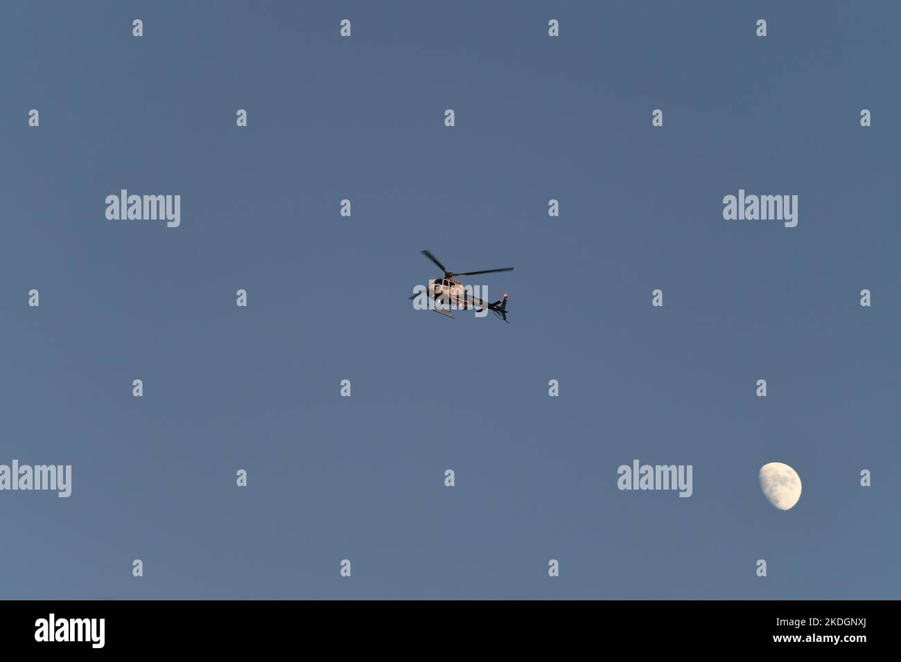 California Highway Patrol (CHP) Hubschrauber auf Patrouille mit Mond im Hintergrund vor der Ankunft von Präsident Joe Biden in der Air Force 1 Stockfoto