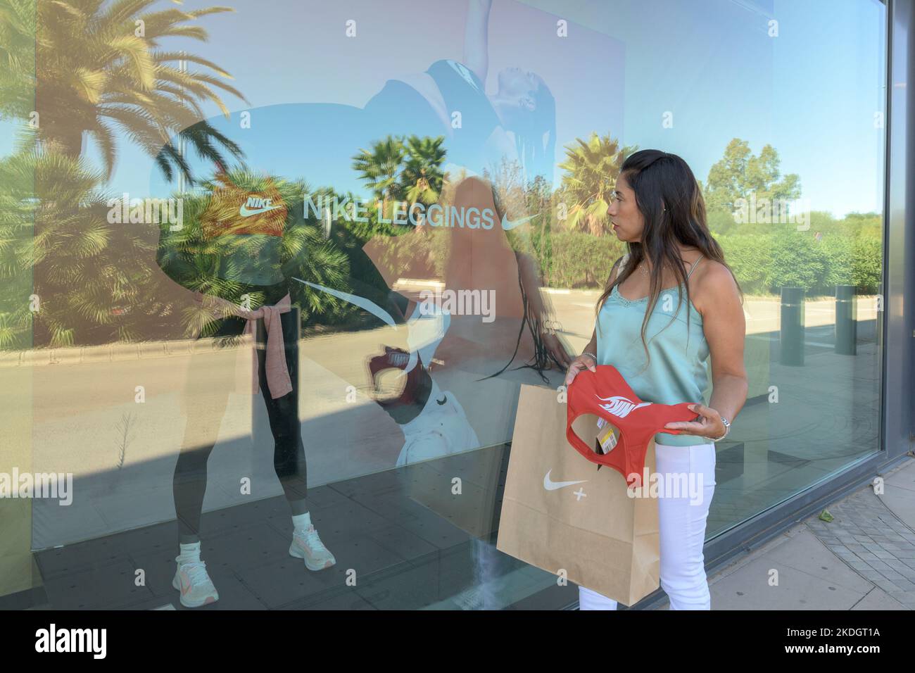 mallorca, balearen spanien-november 05 2022: hispanische Frau schaut auf das Fenster des nike Sports Store und vergleicht den Kauf gerne Stockfoto