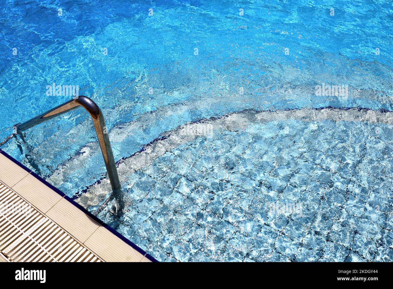 Stufen zum Abstieg in das Schwimmbad mit einem Metallgeländer. Sicherheit für den Wassersport Stockfoto