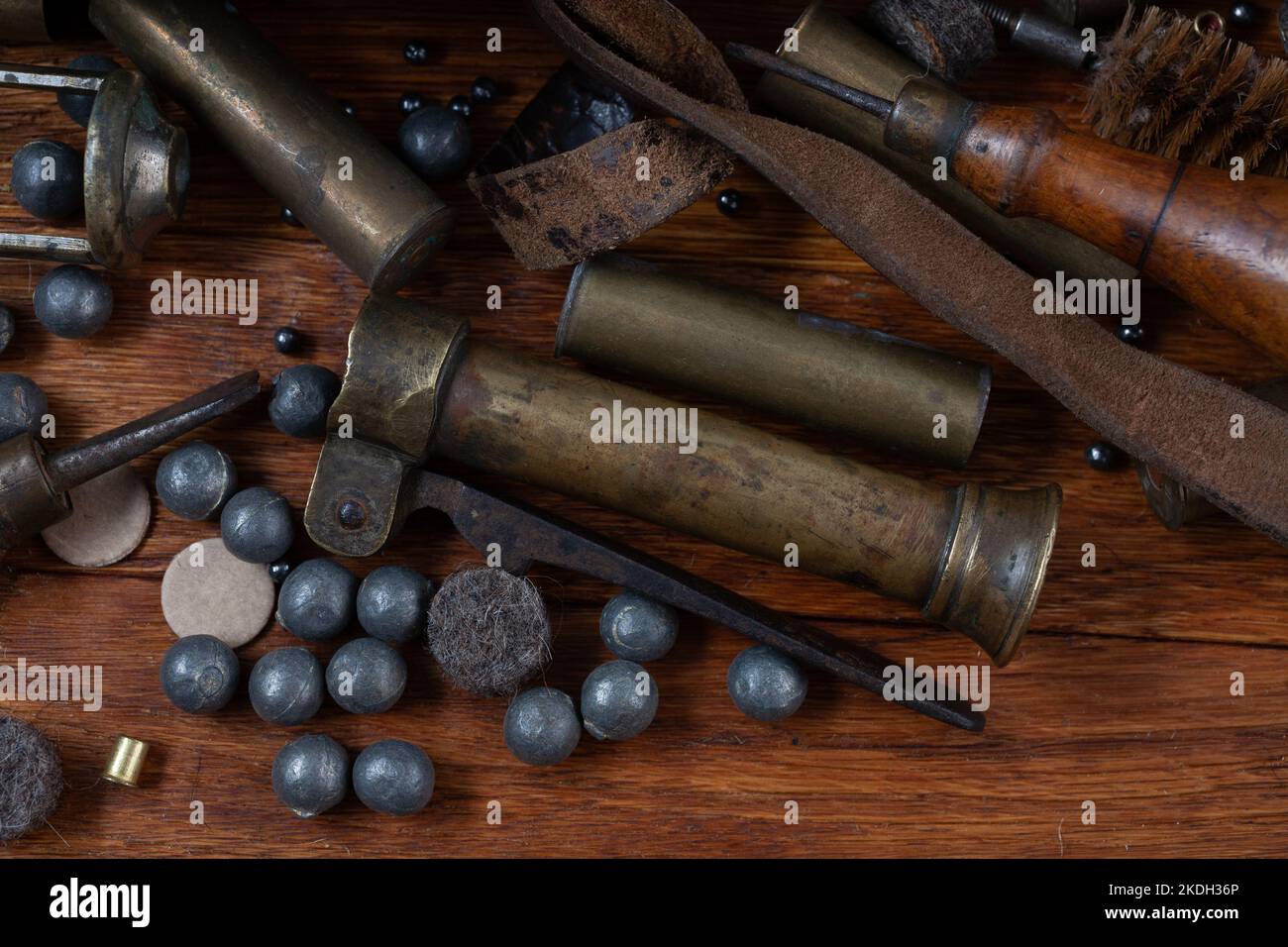 Antike 16-Gauge Break-Action glatt gebohrte Schrotflinte mit Messinggehäuse und Zubehör für Patronennachladung auf Holztisch. Stockfoto