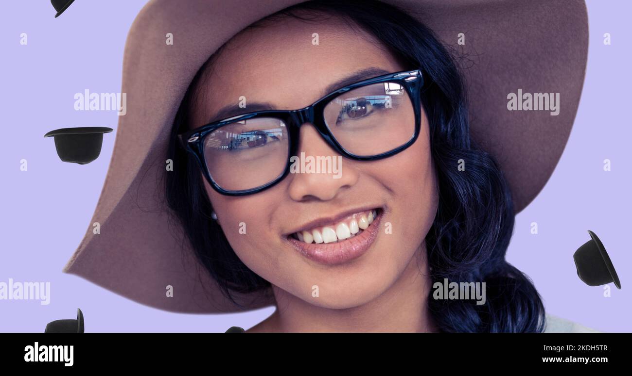 Nahaufnahme einer lächelnden jungen asiatischen Frau mit Brille und Hut mit digitaler Kopfbedeckung Stockfoto