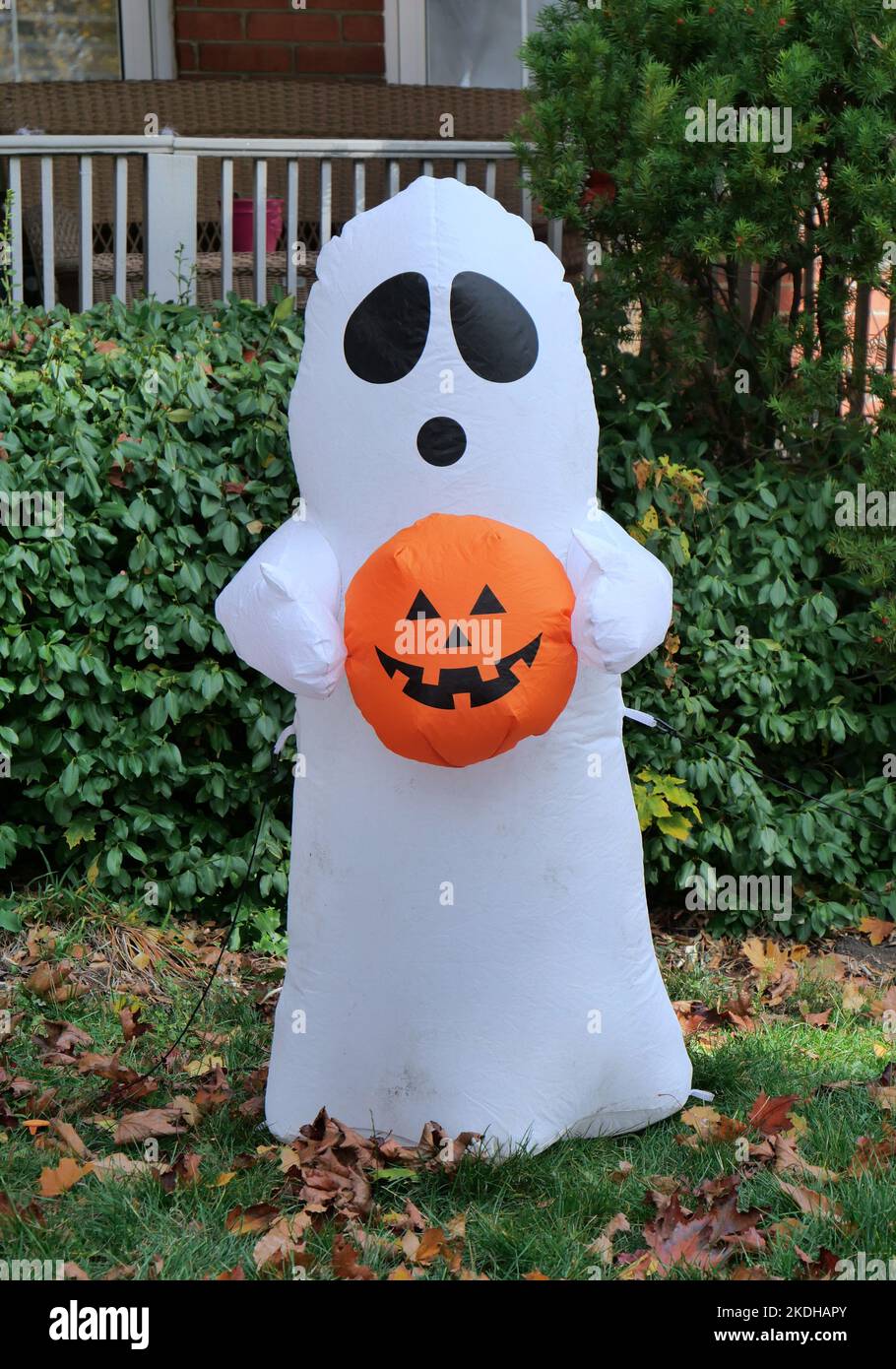 Halloween-Dekoration im Vorgarten eines Hauses, eine Geisterfigur mit einer Jack-o-Laterne Stockfoto