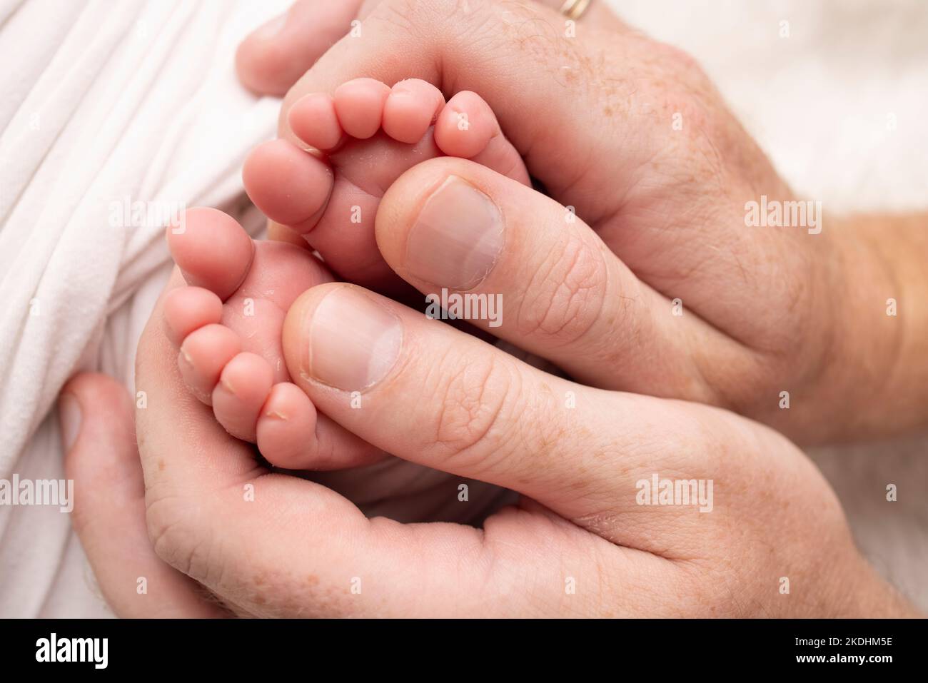 Mutter macht eine Massage auf ihrem Babyfuß. Nahaufnahme der Babyfüße in den Händen der Mutter. Stockfoto