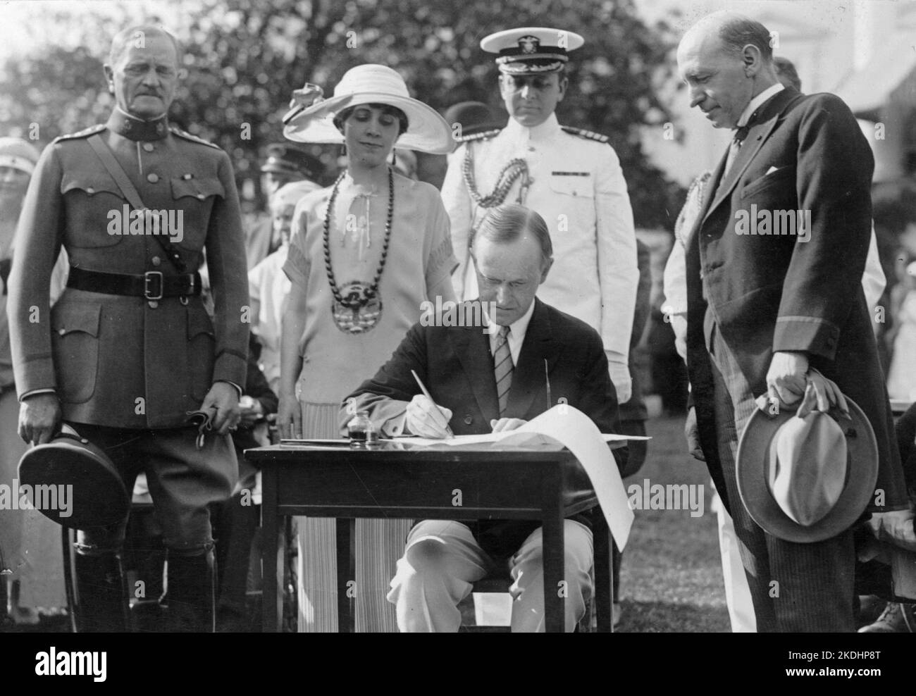 Präsident Coolidge unterzeichnete während der Gartenparty für verwundete Veteranen, 5. Juni 1924, Anteiligungsbescheide für das Veteranenbüro auf dem South Lawn. General John J. Pershing befindet sich auf der linken Seite. Der Mann auf der rechten Seite, der auf ihn schaut, scheint Frank T. Hines, Direktor des Veteranenbüros zu sein. Stockfoto