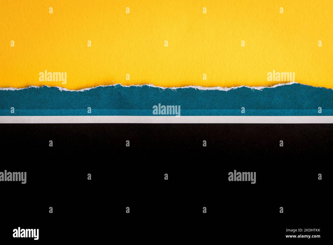 Zerrissenes halbes Blatt blau und schwarz mit weißem Streifenpapier horizontal auf gelbem Papier im Hintergrund. Als Vorlage für Nachrichten oder Werbung. Stockfoto