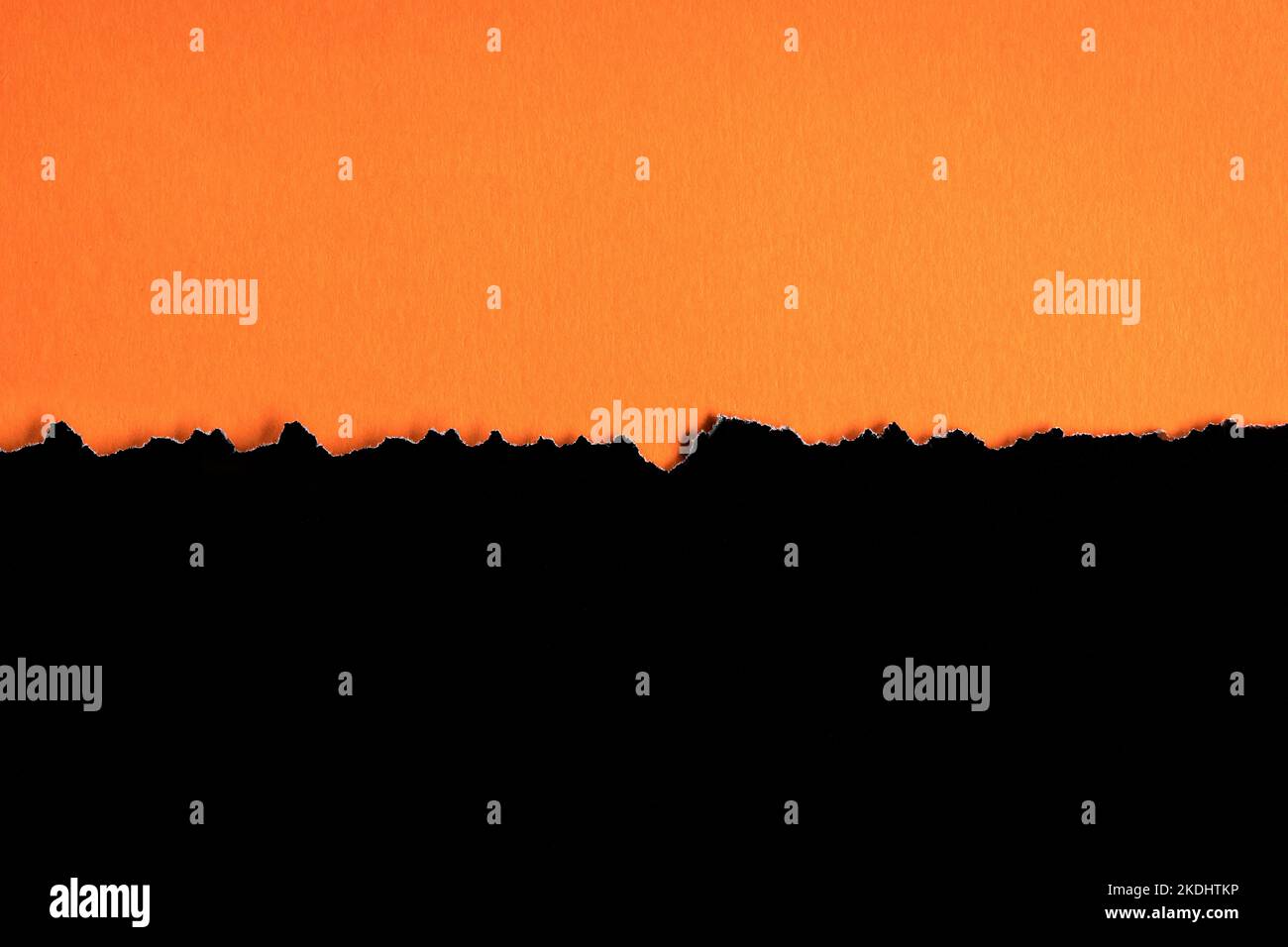 Zerrissenes schwarzes Halbblatt horizontal auf orangefarbenem Papier unten. Als Vorlage für Nachrichten oder Werbung. Stockfoto