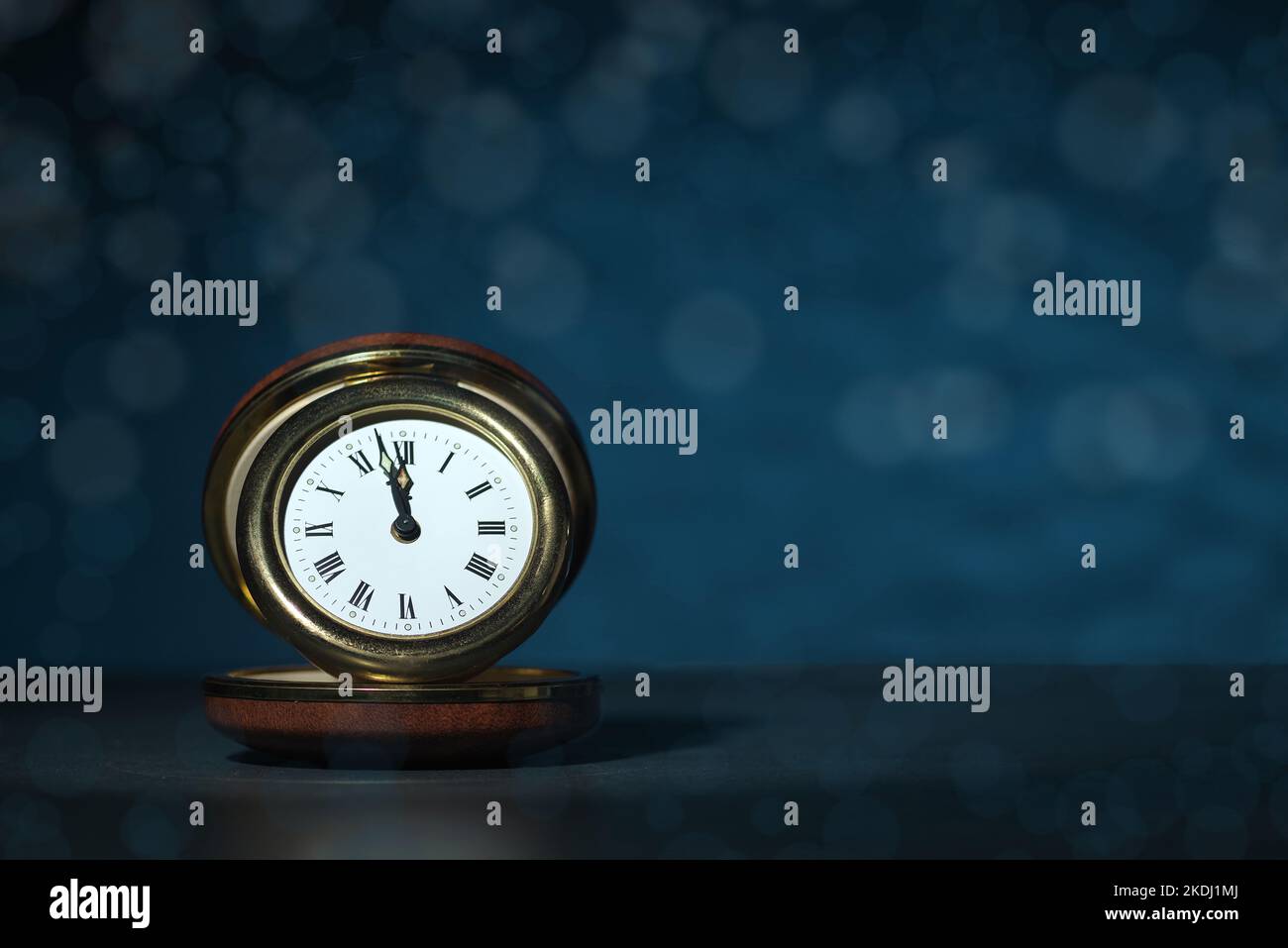 Neujahrskonzept, Uhr gegen Mitternacht 2023, blauer Bokeh-Hintergrund Stockfoto