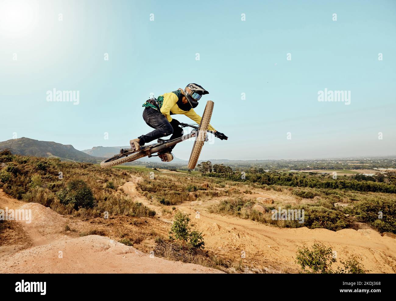Mountainbike, Mann und Luft springen, Action und Fahrrad fahren, Herausforderung und Abenteuer, Freiheit und dynamische Leistung auf blauem Himmel Mockup. Biker Stockfoto