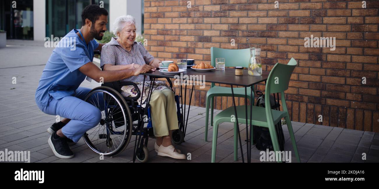 Pfleger beim Frühstück mit seinem Kunden im Café. Stockfoto