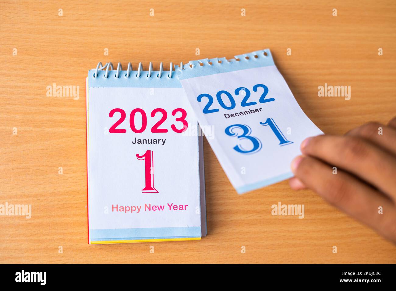 Nahaufnahme der Hände, die den Kalender auf Neujahr 2023 ändern, indem 2022 entfernt wird - Konzept der Neuanfänge Stockfoto