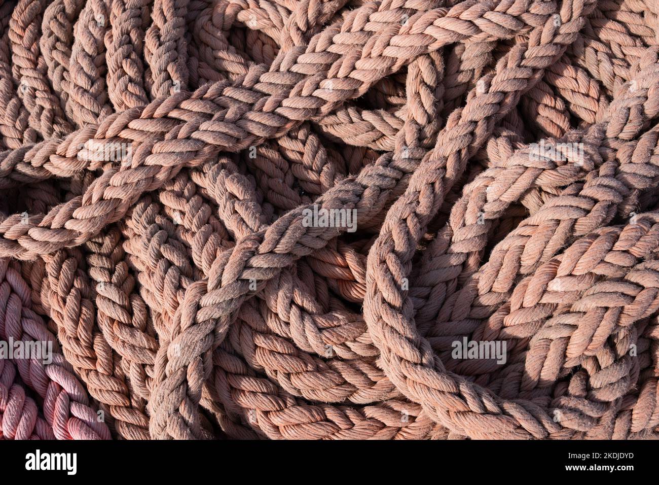 Stapel von dicken Seil von Deck eines Segelschiffs, in geordnete Weise gesetzt, bereit für einfache entfalten, marine Thema Hintergrund. Stockfoto