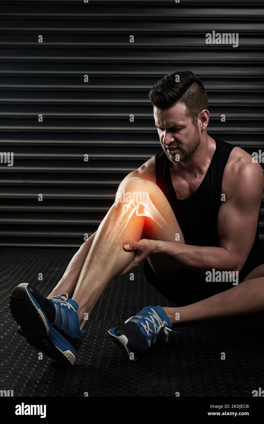 Gehen Sie mit seinem verletzten Knie besonders vorsichtig vor. Studio-Aufnahme eines sportlichen jungen Mannes, der sich vor dem Training aufwärmt. Stockfoto