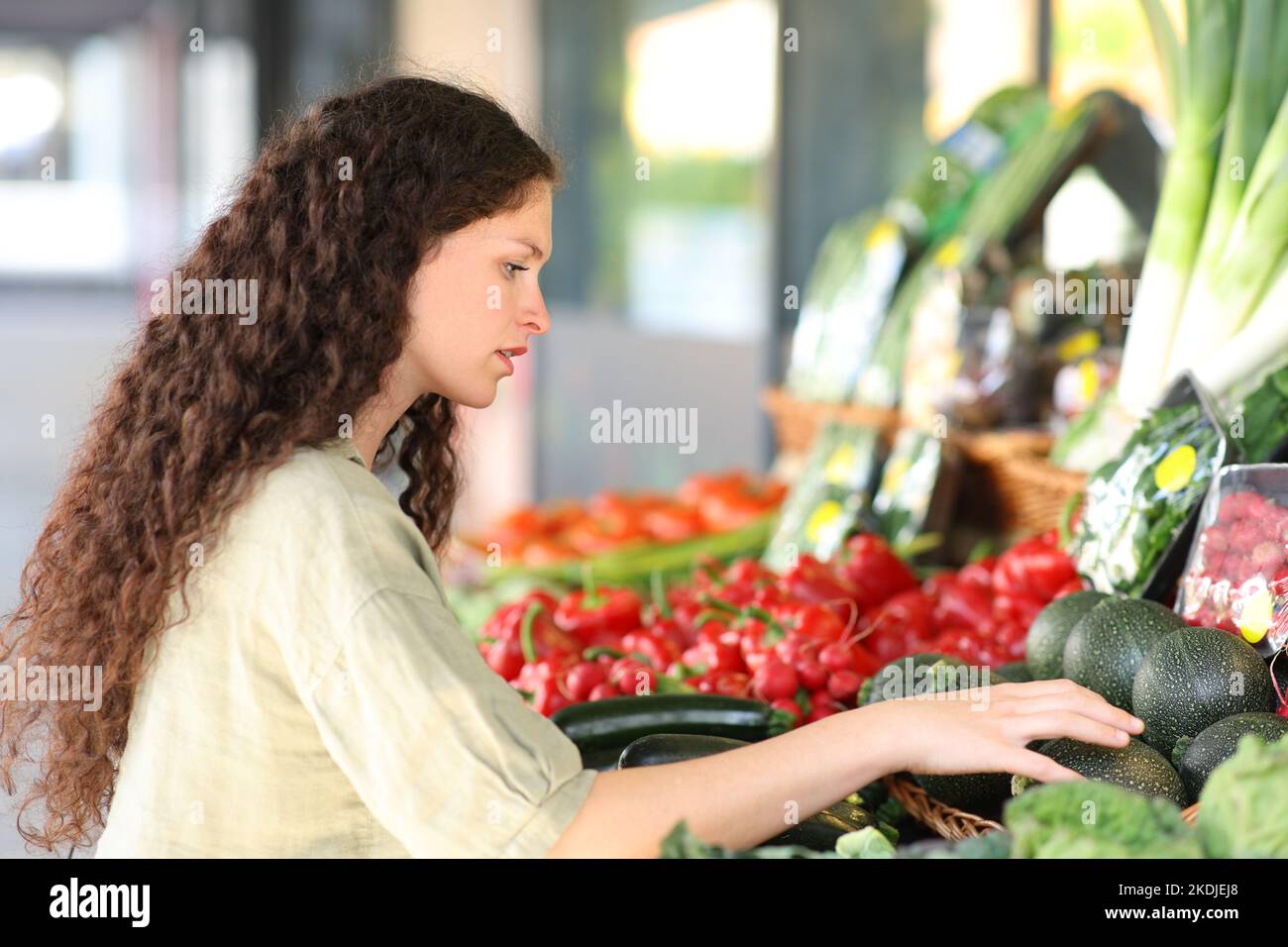 Frau, die Gemüse in einer Greengrocery kauft und auswählt Stockfoto