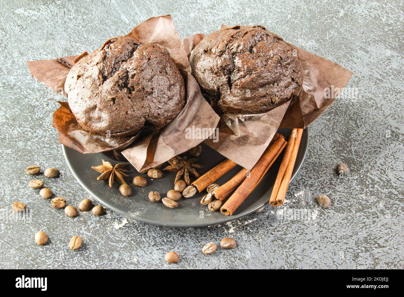 Hausgemachter leckerer Cupcake-Muffin aus Schokolade auf schwarzem Teller und Steinhintergrund Stockfoto