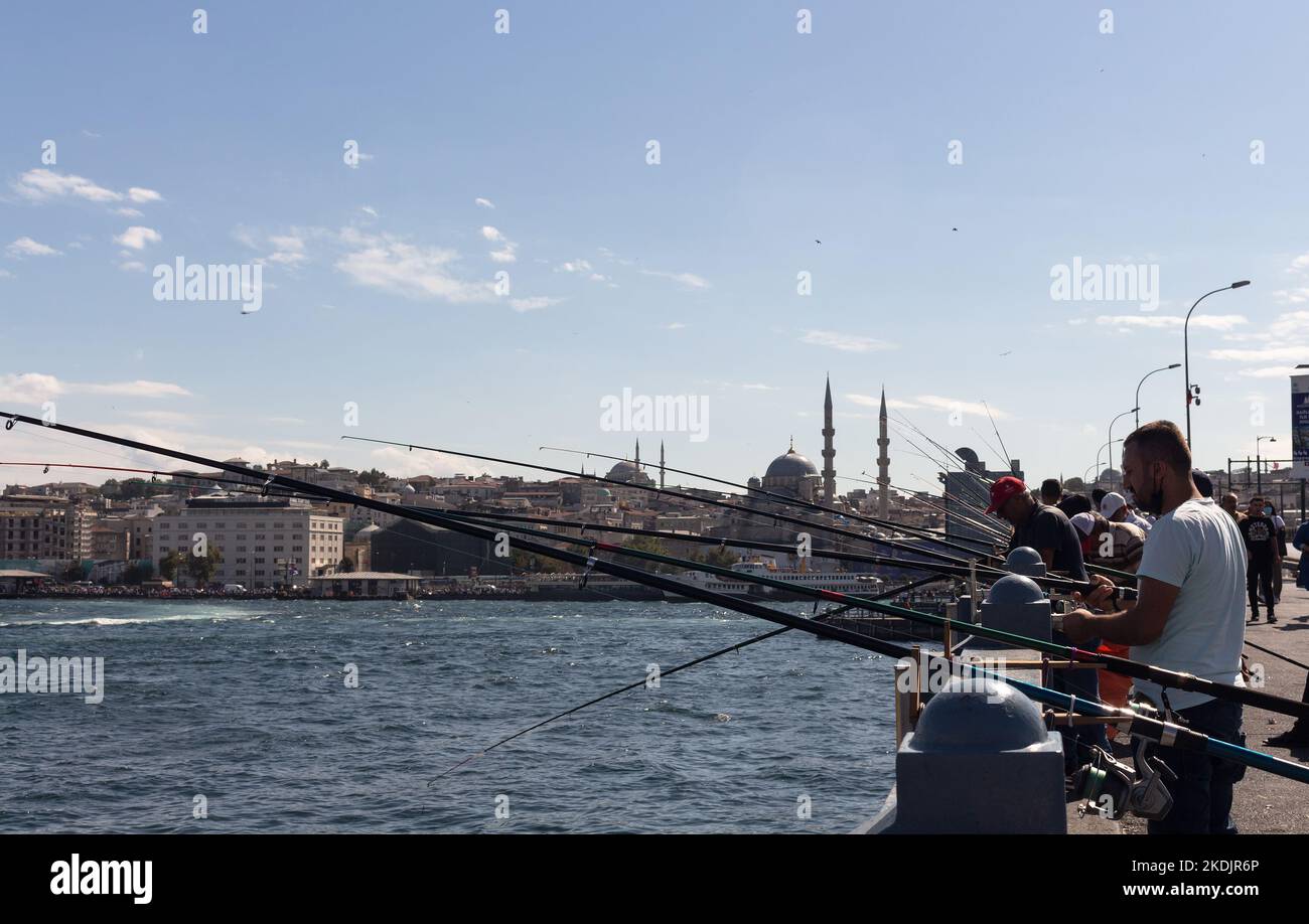 Blick auf die Fischer auf der Galata-Brücke und in der Eminonu-Gegend von Istanbul. Das Bild spiegelt den Lebensstil und die Kultur der Menschen vor Ort wider Es ist ein sonniger Sommertag. Stockfoto