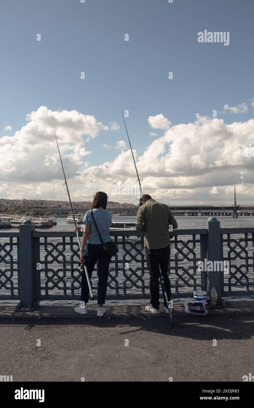 Blick auf die Fischer auf der Galata-Brücke in Istanbul. Das Bild spiegelt den Lebensstil und die Kultur der Menschen vor Ort wider. Es ist ein sonniger Sommertag. Stockfoto