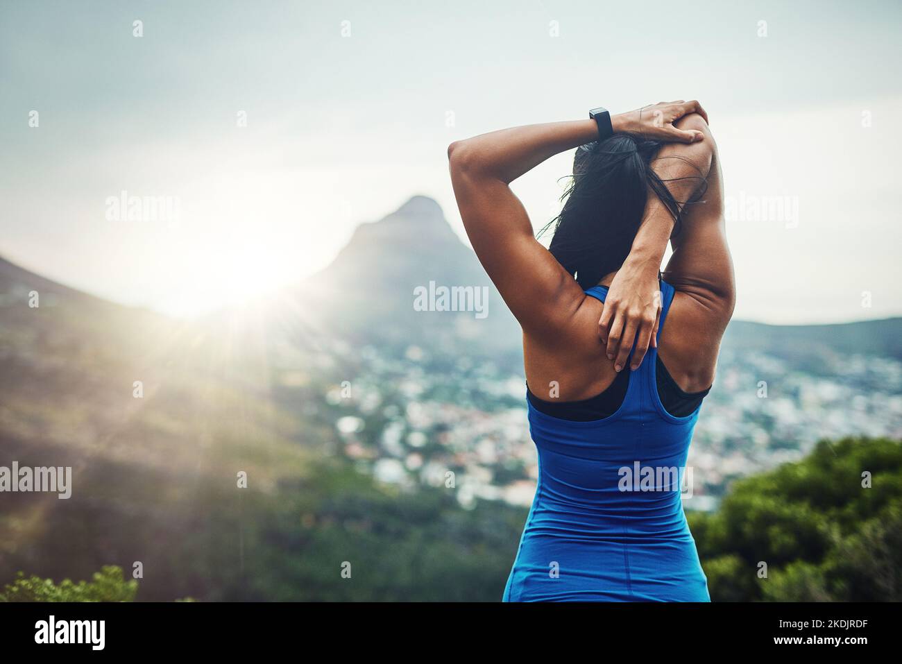 Beginne mit dem Stretching. Eine unkenntliche Frau trainiert für einen Marathon im Freien. Stockfoto