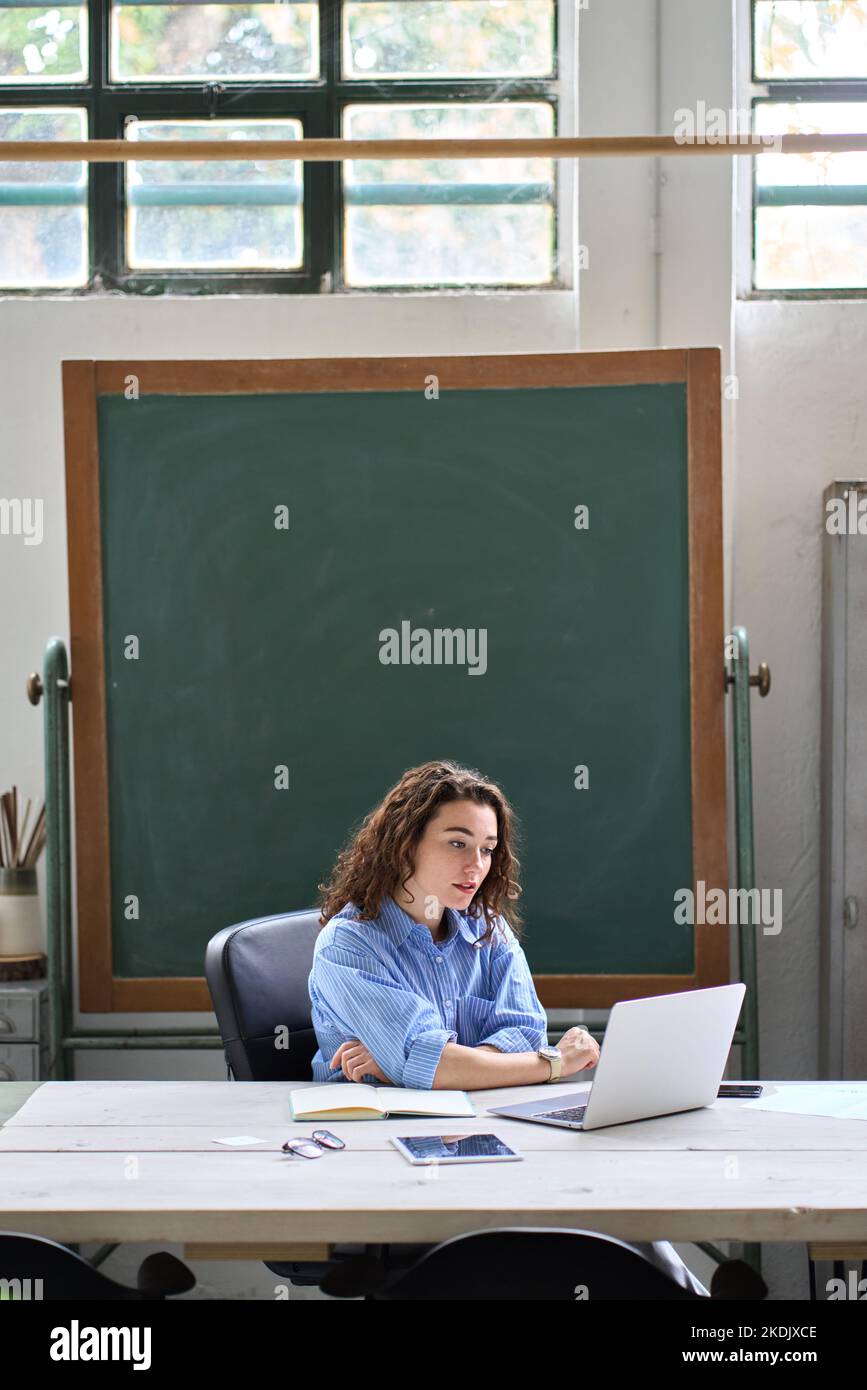 Online-Lehrerin oder Coach mit Fernunterricht auf einem Laptop im Klassenzimmer. Stockfoto