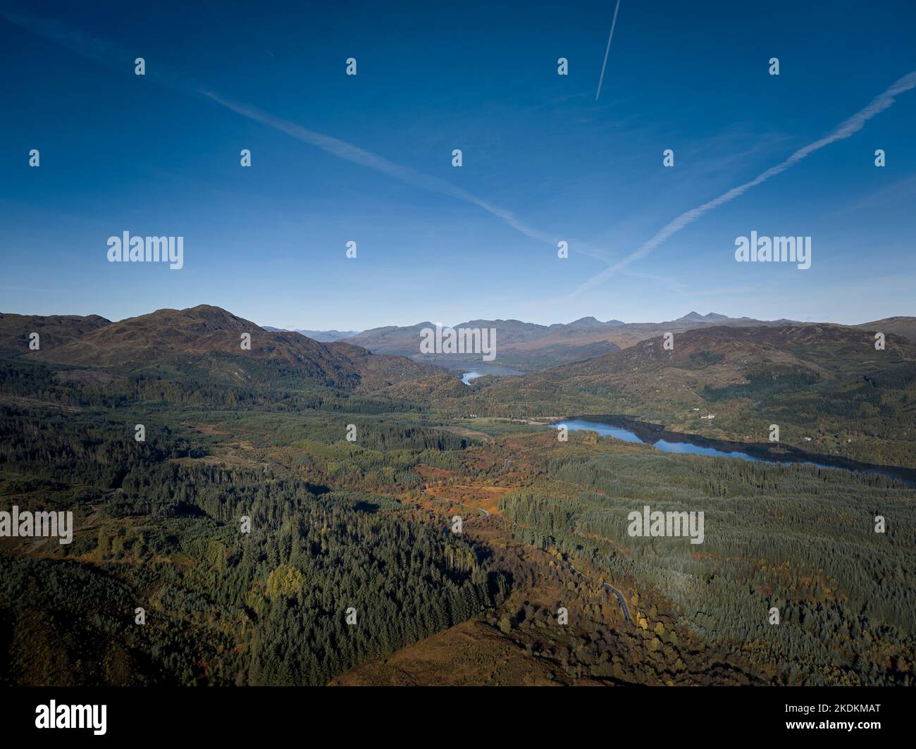 Luftaufnahme des Duke's Pass mit der Straße, die sich an einem sonnigen Herbsttag durch die Forstwirtschaft nach Loch Achray und Loch Katrine in den Trossachs schlängelt. Stockfoto