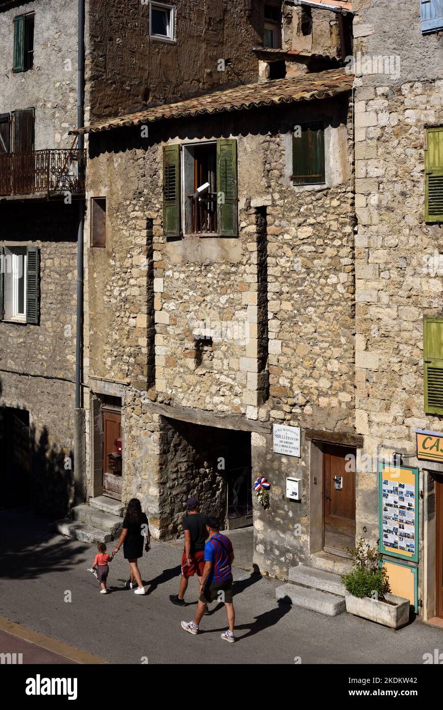 Touristen gehen am mittelalterlichen Stadttor oder am Eingang zur Altstadt oder zum historischen Viertel von Castellane Alpes-de-Haute-Provence Provence France vorbei Stockfoto