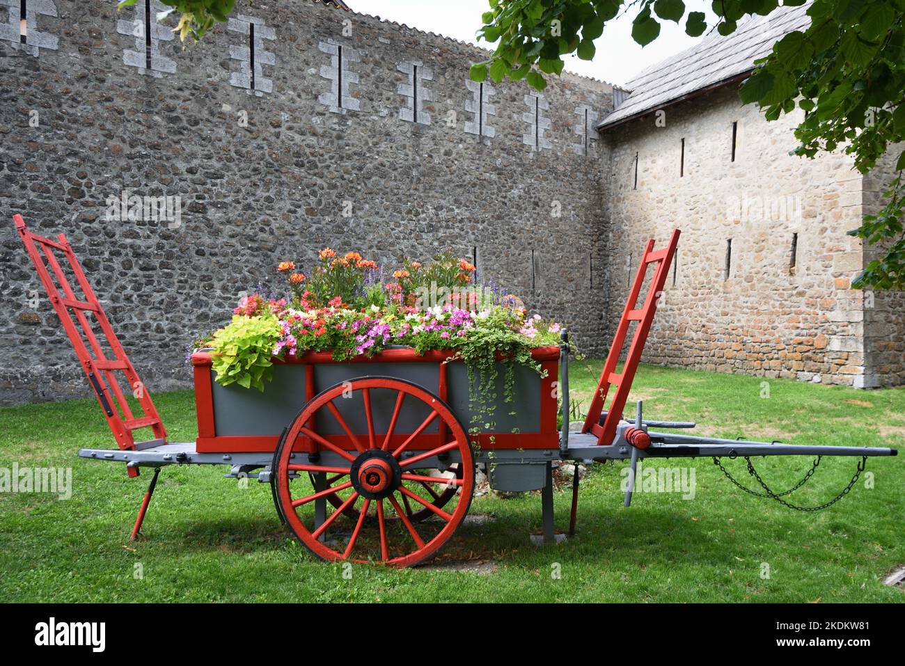 Alte hölzerne Heuwagen oder Farm Wagon restauriert, bemalt und verwendet als dekorative Blumentopf oder Blumenanzeige Colmars-les-Alpes Provence Frankreich Stockfoto