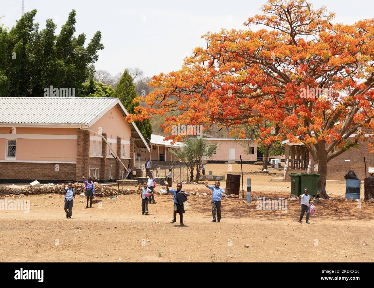 Grundschule Afrika; 10-jährige afrikanische Schüler winken vor ihrer Schule, Kasane Stadt, Botswana Afrika. Bildung in Afrika Stockfoto