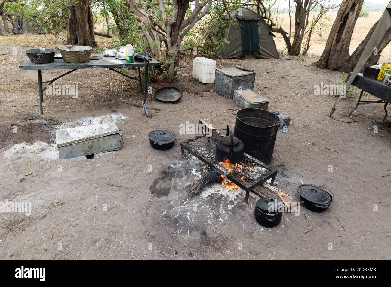 Der Koch- und Küchenbereich, inklusive offenem Feuer und Metallofen - Ausrüstung auf einer mobilen Zeltsafari, dem Okavango Delta, Botswana Afrika. Stockfoto