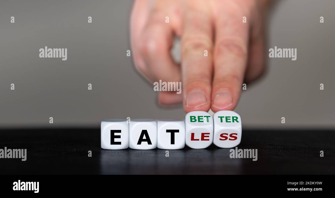Die Hand dreht Würfel und ändert den Ausdruck „weniger essen“ in „besser essen“. Stockfoto