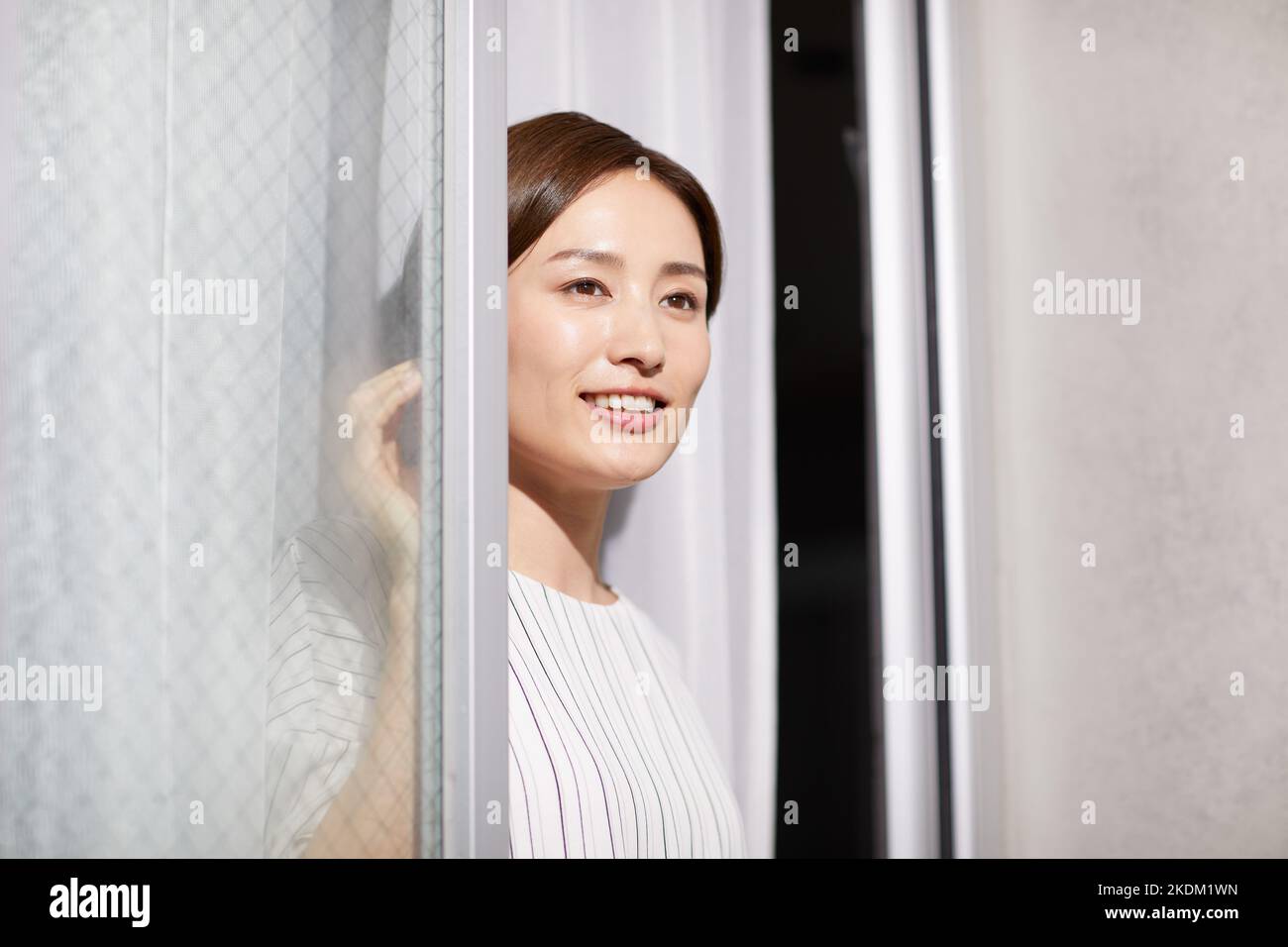 Japanische Frau, die aus dem Fenster schaut Stockfoto