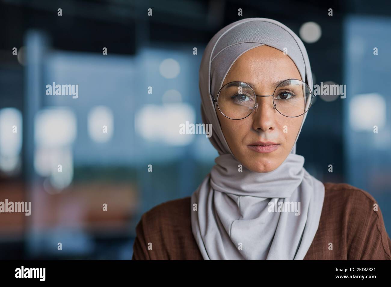 Nahaufnahme Porträt einer erfolgreichen denkenden Geschäftsfrau mit Hijab und Brille, Frau mit Blick auf die Kamera, die im modernen Bürogebäude arbeitet. Stockfoto