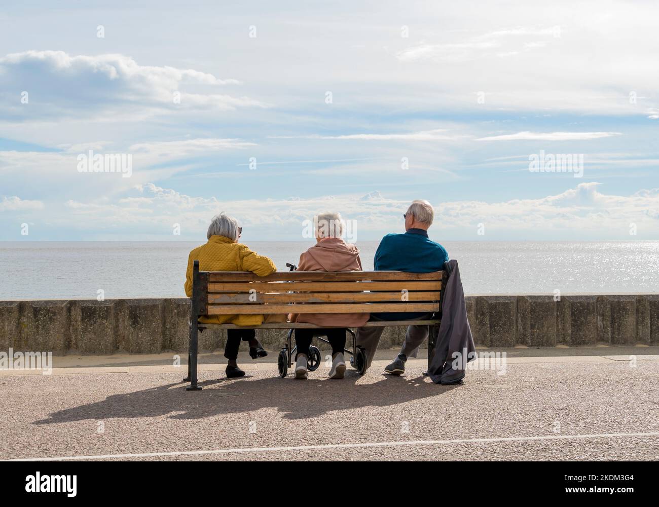 Mann und zwei Damen genießen die frühe Herbstsonne Lowestoft Seafront 2022 Stockfoto