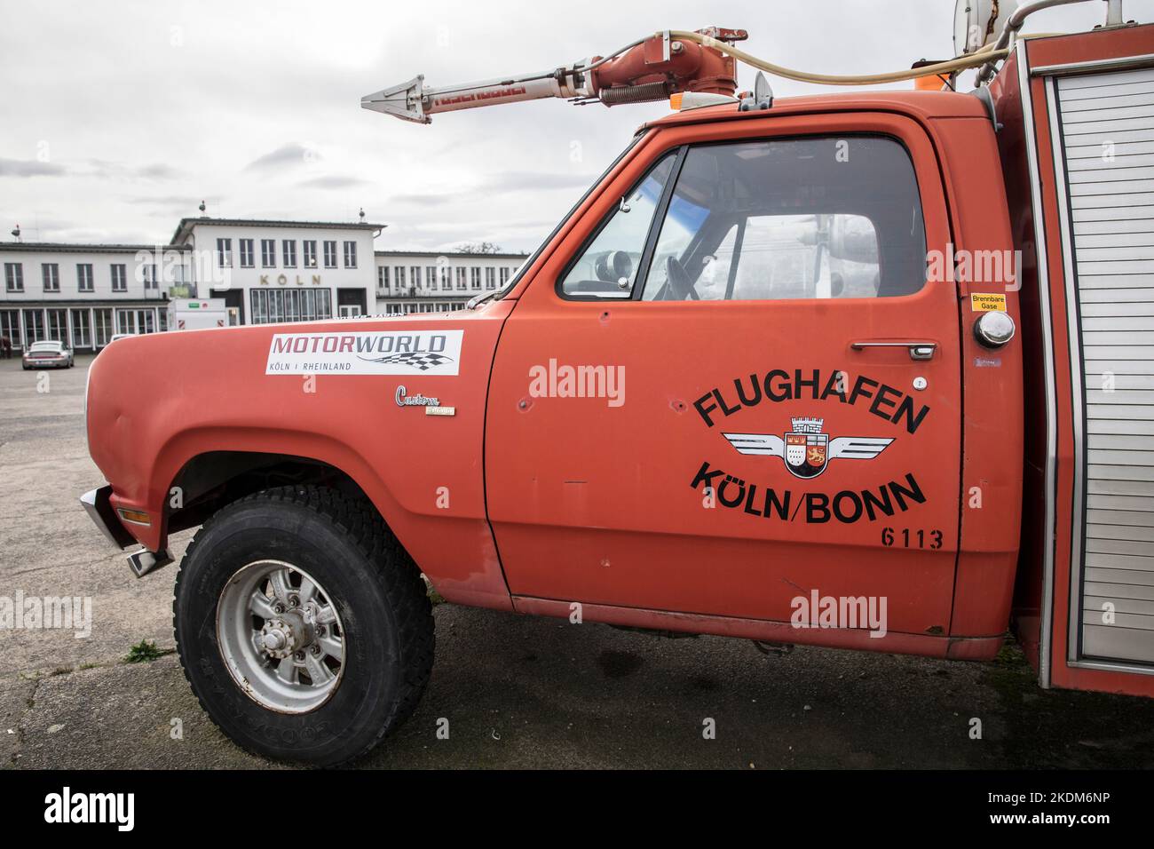 Altes Feuerwehrfahrzeug vor dem Hauptgebäude des ehemaligen Flughafens Butzweilerhof im Stadtteil Ossendorf, Köln, Deutschland. Altes Feuerloe Stockfoto