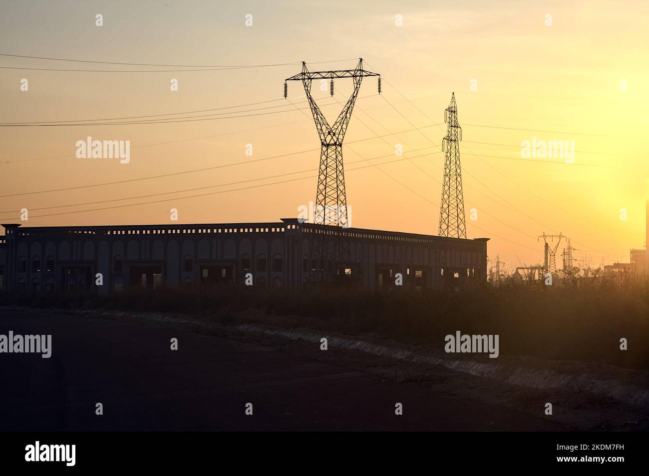 Leere Straße mit verlassenen Lagerhäusern und Pylonen bei Sonnenuntergang Stockfoto