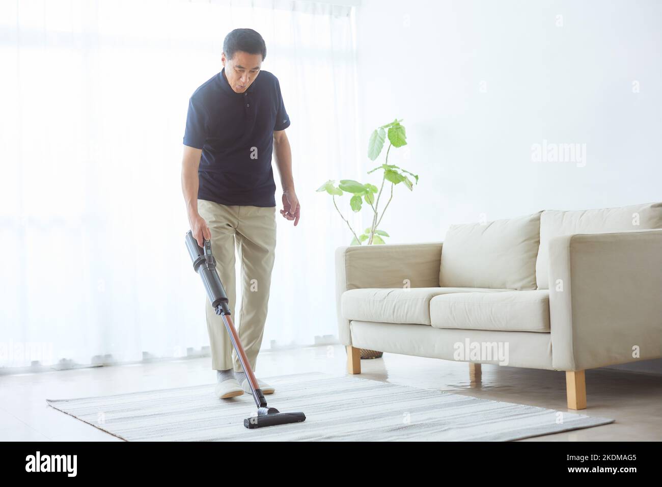 Japanischer älterer Mann, der zu Hause putzt Stockfoto