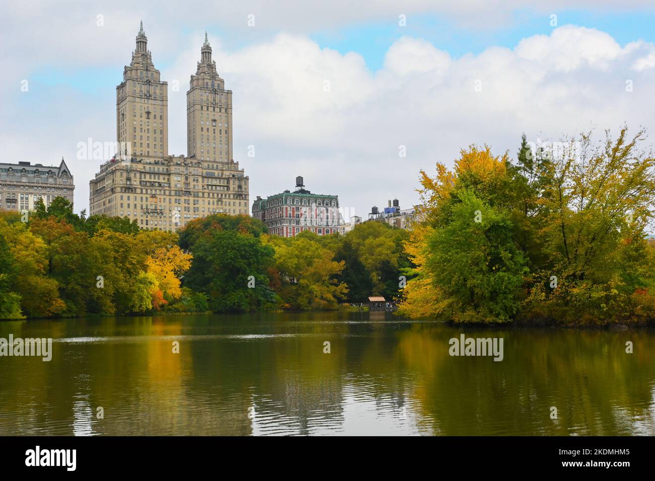 NEW YORK - 23 Okt 2022: Der Central Park Lake mit dem San Remo und seinen Zwillingstürmen und den Kenilworth Gebäuden im Hintergrund. Stockfoto