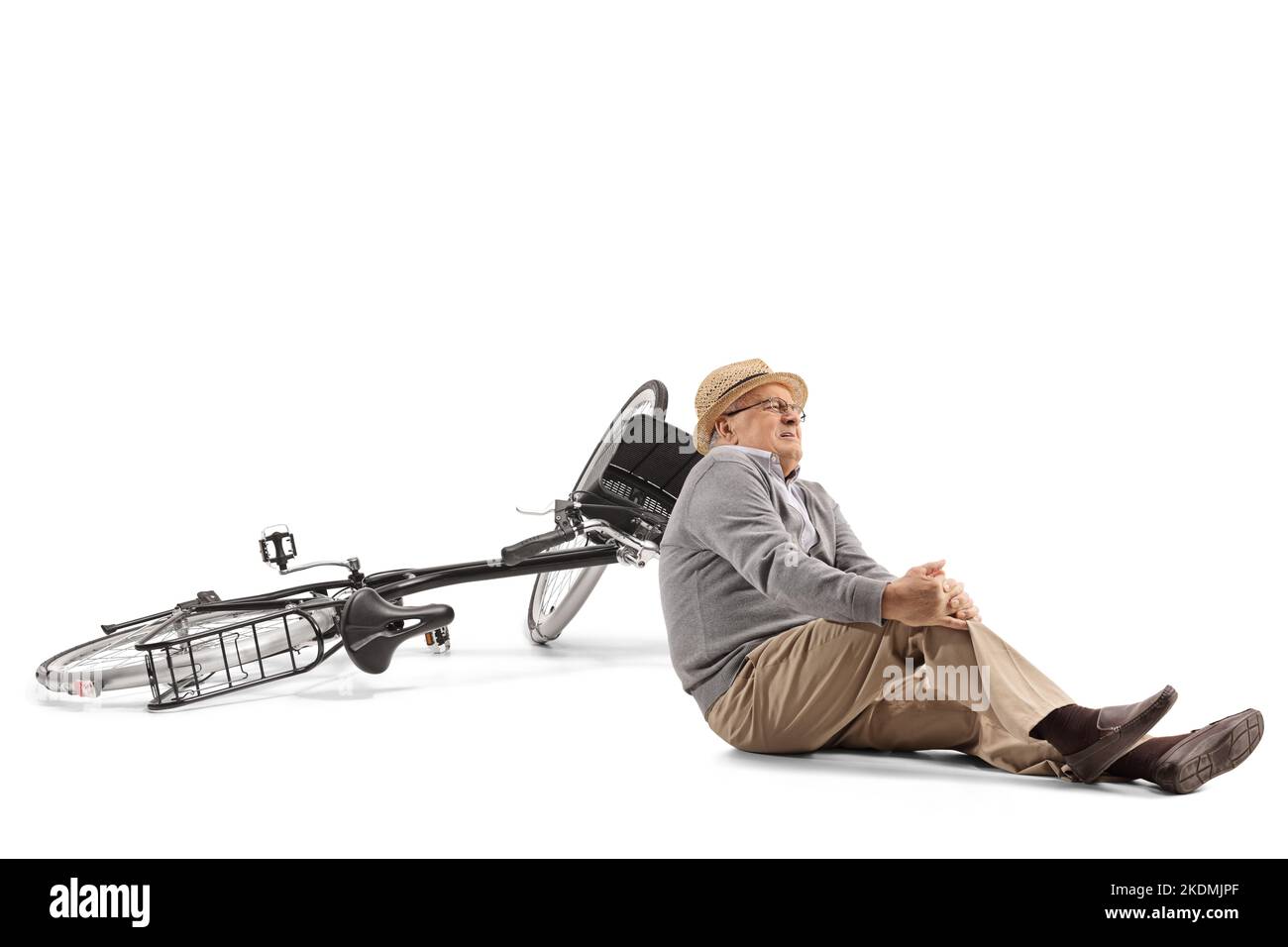 Älterer Mann, der von einem Fahrrad fällt und sein Knie isoliert auf weißem Hintergrund hält Stockfoto