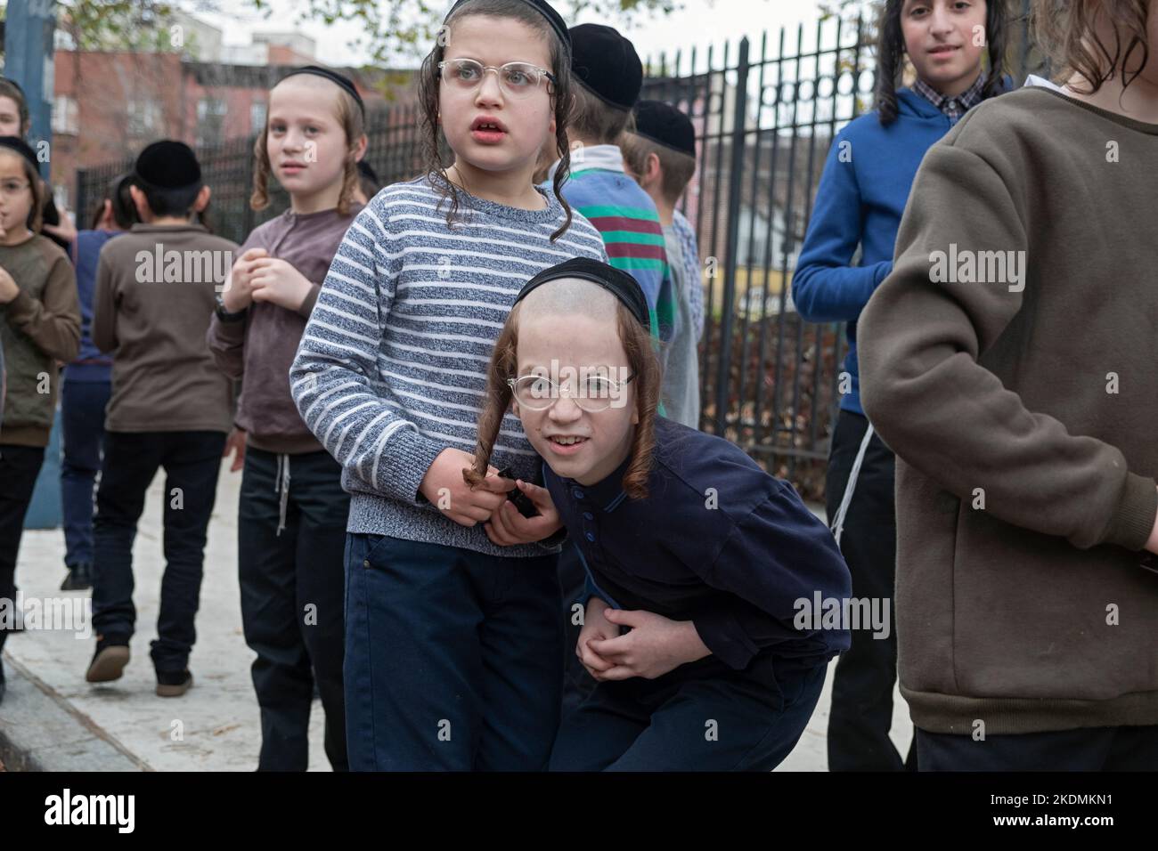 Orthodoxe jüdische Jungen spielen in der Pause vor der Vizhnitz Yeshiva in Brooklyn, New York. Stockfoto