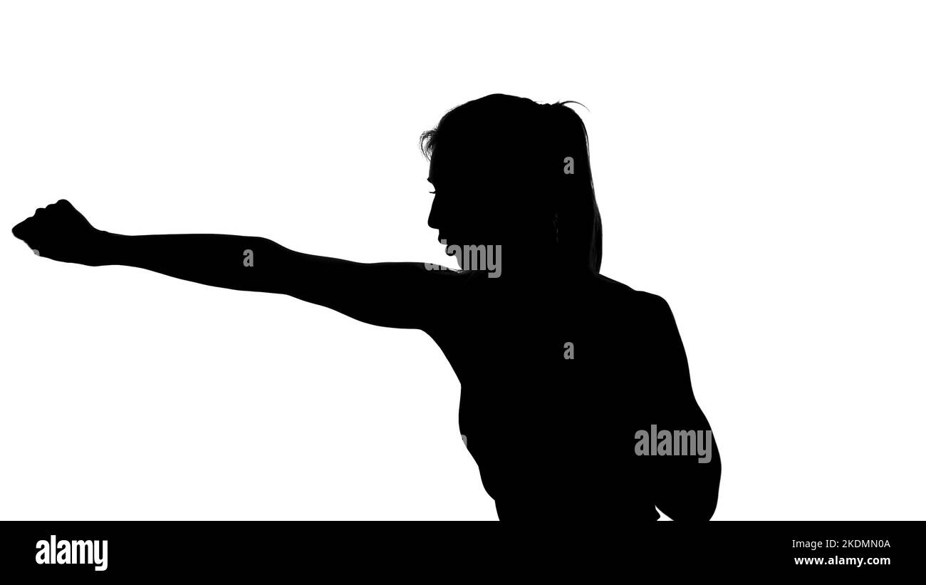 Auf weißem Hintergrund ein Schatten, ein schwarzer Umriss einer weiblichen Figur, die Boxbewegungen macht, ein Kampf mit einem Schatten, Kickboxen, Imitationen von Schlägen, Kampftechniken,. Hochwertige Fotos Stockfoto