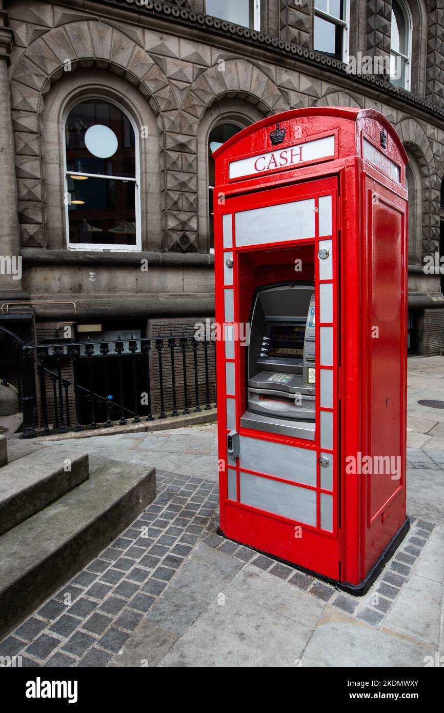 LEEDS, GROSSBRITANNIEN - 30. SEPTEMBER 2022. Eine rote britische Telefonzelle in Großbritannien, die in einen Geldautomaten an einer Straße in einer britischen Stadt umgewandelt wurde Stockfoto