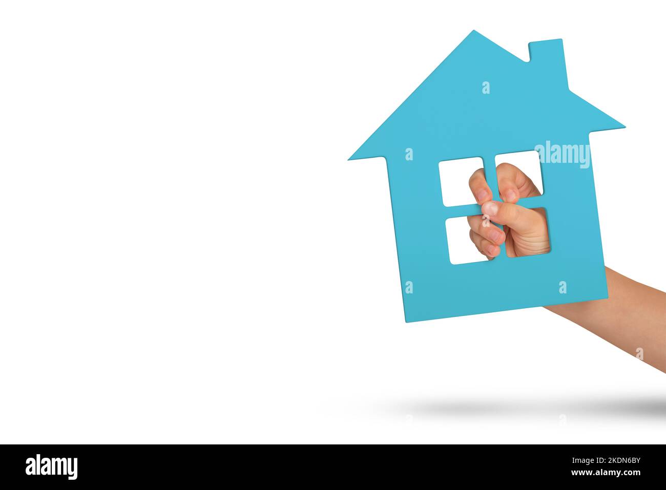 Haus in der Hand, Isolation. Grünes Modell eines Hauses in den Händen eines Kindes isoliert auf weißem Hintergrund. Obdachlosenheim, Familienheim, Hausversicherung Stockfoto