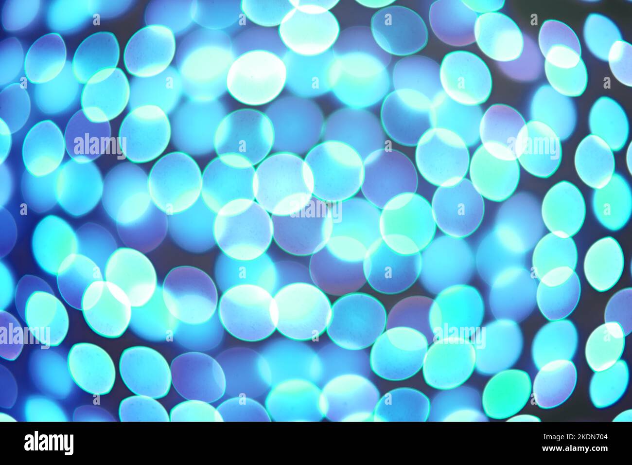 Abstrakt verschwommener Hintergrund, unscharf türkis verschwommen Lichter Bokeh auf schwarzem Hintergrund. Glitzerndes, leuchtendes Kreismuster. Festliche Tapete, Backdro Stockfoto