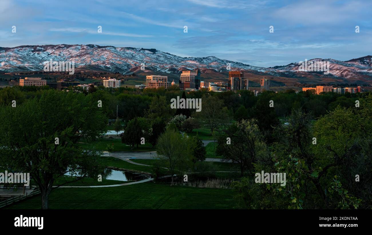 Ann Morrison Park im Vordergrund und die Berge im Hintergrund sorgen dafür, dass die Frühlingssonne im Zentrum von Boise, Idaho, untergeht Stockfoto