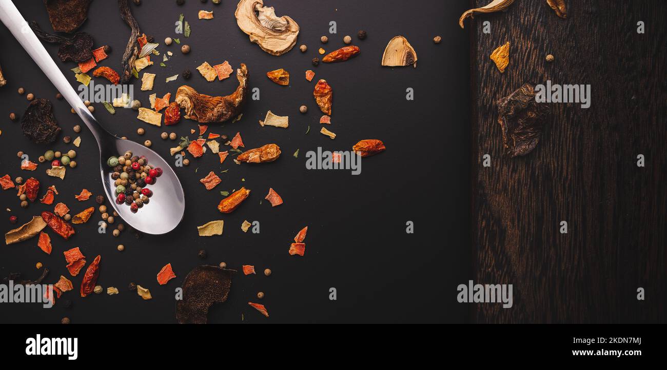 Nahaufnahme von getrockenen Gewürzen wie Chilipilzen und Pfeffer auf dunkler Oberfläche oder Tisch mit Variationen in der feinen Küche mit Kopierfläche Stockfoto