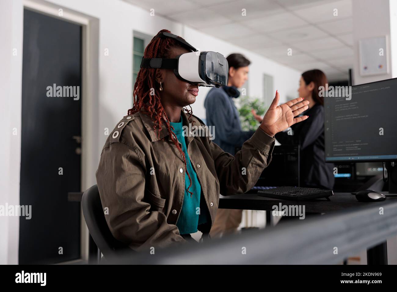 afroamerikanischer Datenbankadministrator arbeitet mit Virtual-Reality-Brille, um Server-App im Büro der IT-Agentur zu entwickeln, mit Quellcode. Überprüfung der Programmiersprache auf Cloud-Computing-Datenbank, Web-Entwickler. Stockfoto