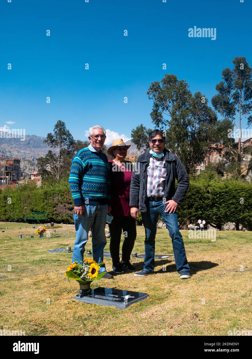 La Paz, Bolivien - 14. August 2022: Zwei Bolivianer mit einer Frau mit einem Hut in der Mitte schauen auf die Kamera im Garten des Friedhofs auf einem Su Stockfoto