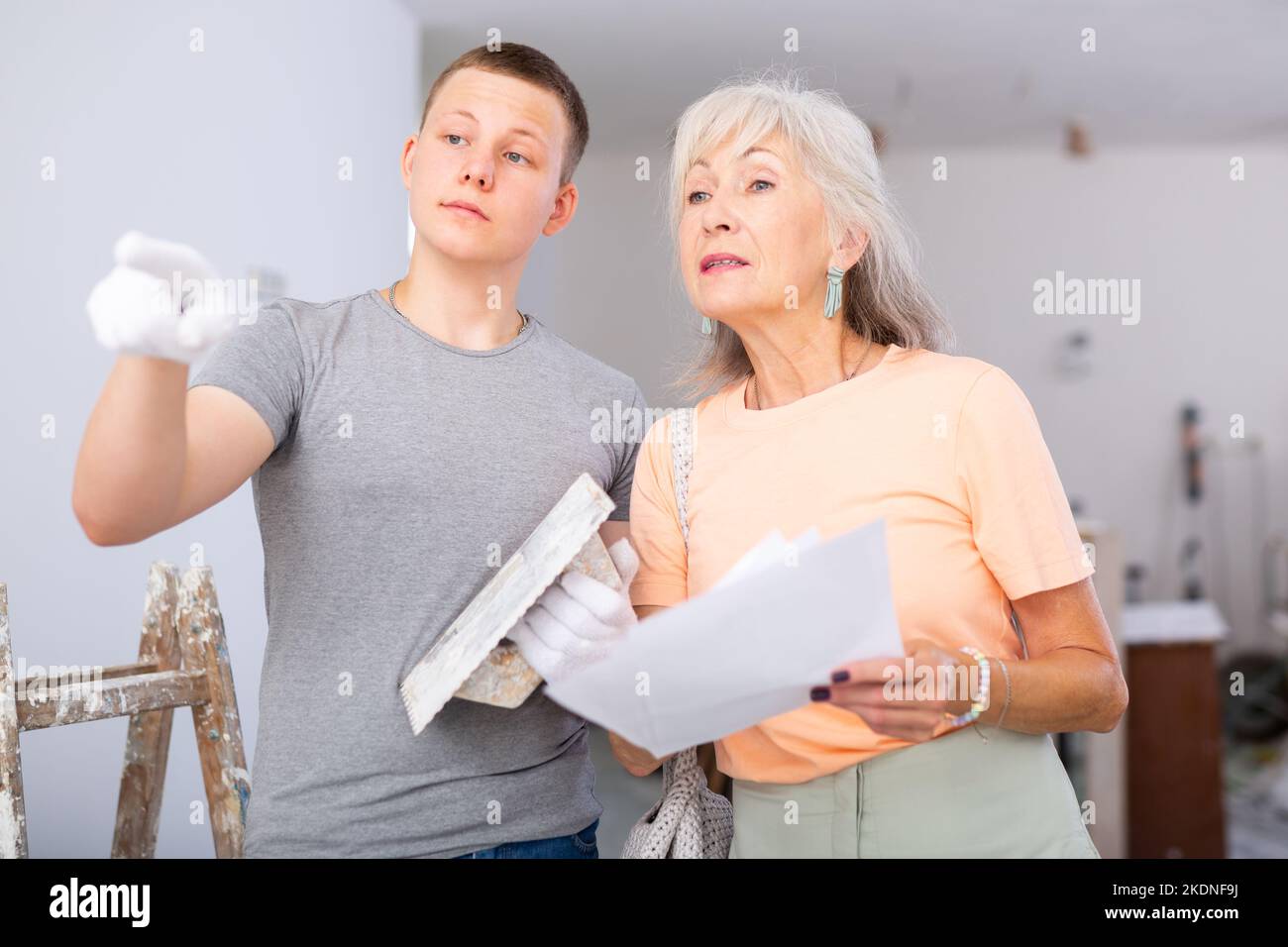 Großmutter und Enkel diskutieren über die Zeichnungen eines Wohnzimmers, das renoviert wird Stockfoto