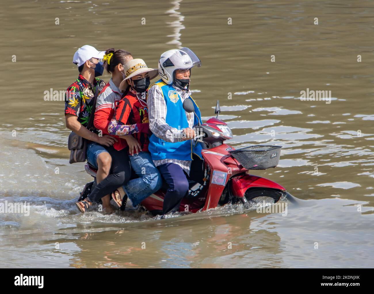 SAMUT PRAKAN, THAILAND, Okt 29 2022, Eine Gruppe von Menschen fährt ein Moto-Taxi auf einer überfluteten Straße Stockfoto